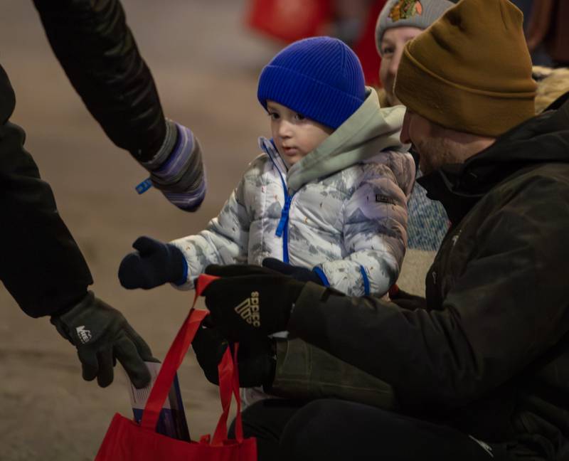 Christian Houghtaylen, 2, of Westmont receives candy during the annual Holly Days Frosty & Friends Parade in Westmont on Saturday, December. 7, 2024.