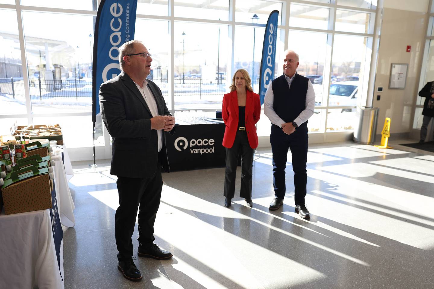 Joliet City Manager Beth Beatty and Mayor Terry D’Arcy listen as Pace Chairman Nick Kwasneski, left, speaks at the official launch of the Pace VanGo vanpool reservation-based round-trip service on Thursday, Dec. 4, 2025 in Joliet.