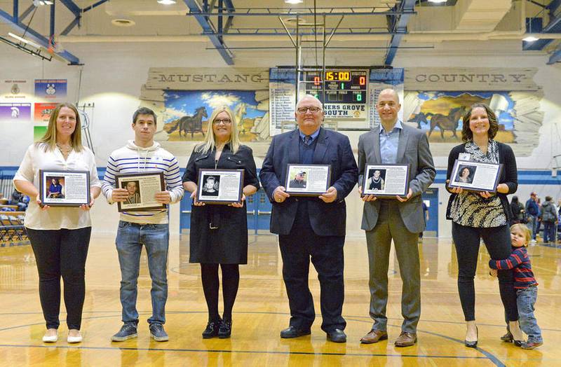 Julie (Todd) Mesmer (from left), Mark Lenkowski, Denise Lazzeroni-Kavanaugh, Ron Havelka, Greg Ktistou, and Megan (Rossi) Bremer are the 2017 inductees of the Downers Grove South High School Athletic Hall of Fame are inducted on Saturday, Jan. 28, 2017. Liam Bremer, 2, photo bombs the group photo. Bill Ackerman for Shaw Media