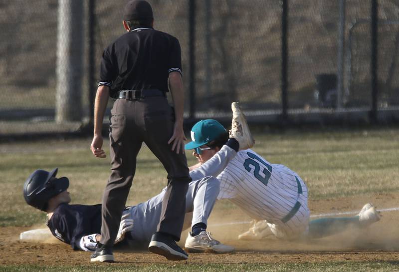 Cary-Grove's Charlie Taczy is tagged out by Woodstock North's Matthew Fansler as Taczy tried to stretch a double into a triple during a nonconference baseball game on Monday, March 30, 2026, at Woodstock North High School.