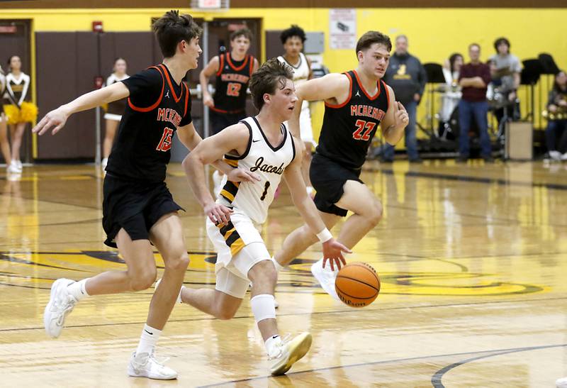 Jacobs' Ben Jurzak (center) pushes the ball up the court against McHenry's Blake Renfro (left) and Conner McLean (right) during a Fox Valley Conference basketball game on Friday, Jan. 24, 2025, at Jacobs' High School.