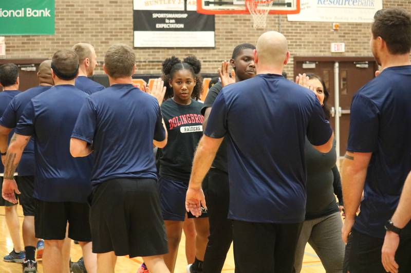 Members of both teams give high-fives to one another at the conclusion of the Toys for Tots community basketball game. DeKalb District 428 faculty sealed a victory over the Guns and Hoses in a 51-50 matchup Monday, Dec. 5, 2022.