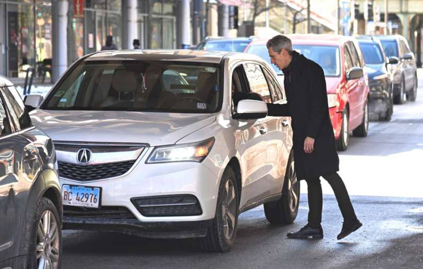 Evanston Mayor Daniel Biss talks with a woman waiting for a red light in Evanston on Wednesday, March 18, 2026. He won the Democratic nomination for Illinois’ 9th Congressional District seat the night before.