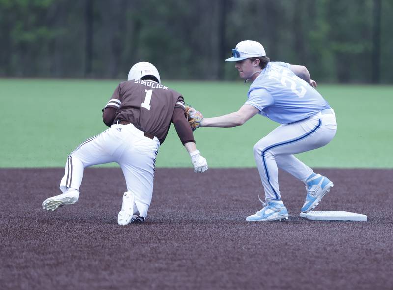Nazareth's Landon Thome (25) tags out Joliet Catholic's (1) Lucas Simulick after overrunning second base during the varsity baseball game on Wednesday, April 20, 2025 between Nazareth and Joliet Catholic academies in La Grange Park.
