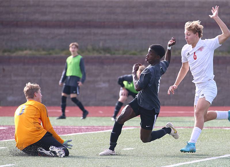 Timothy Christian's keeper Peter Buikema stops a shot on goal from Wheaton Academy's Josiah Pitts (11) as Timothy Christian's Ethan Munk (6) chases him from behined during the Class 1A State soccer third place game on Saturday, Oct. 29, 2022 at EastSide Centre in Peoria.