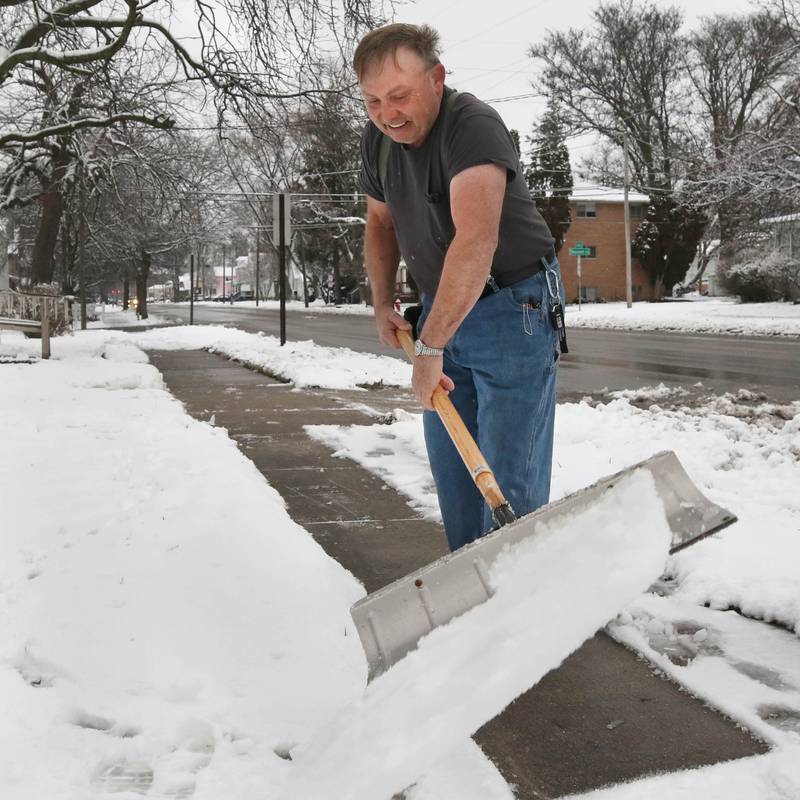 Steve Foltz doesn’t let the weather bother him as he shovels the walk in front of his house wearing a T-shirt on Tuesday, Jan. 9, 2024, in DeKalb. Snow is expected to continue throughout the day with 7 to 10 inches of snow expected.