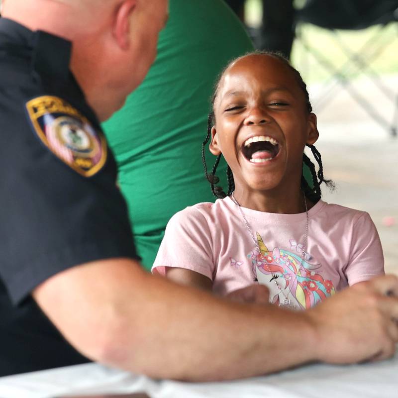 Mariah Cotton, 10, from DeKalb, has a laugh with DeKalb Deputy Police Chief Jason Leverton during Fun Jam in the Park Tuesday, June 27, 2023, at Welsh Park in DeKalb. Fun Jam in the Park offers constructive activities for kids on Tuesday and Thursday through August 8th from 5-7 p.m. at various parks in DeKalb.