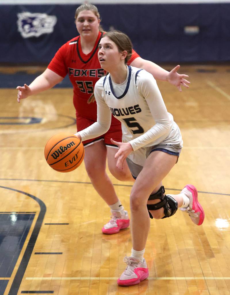 Oswego East's Lillie VanDyke drives by Yorkville's Madison Spychalski during their game Tuesday, Feb. 11, 2025, at Oswego East High School.