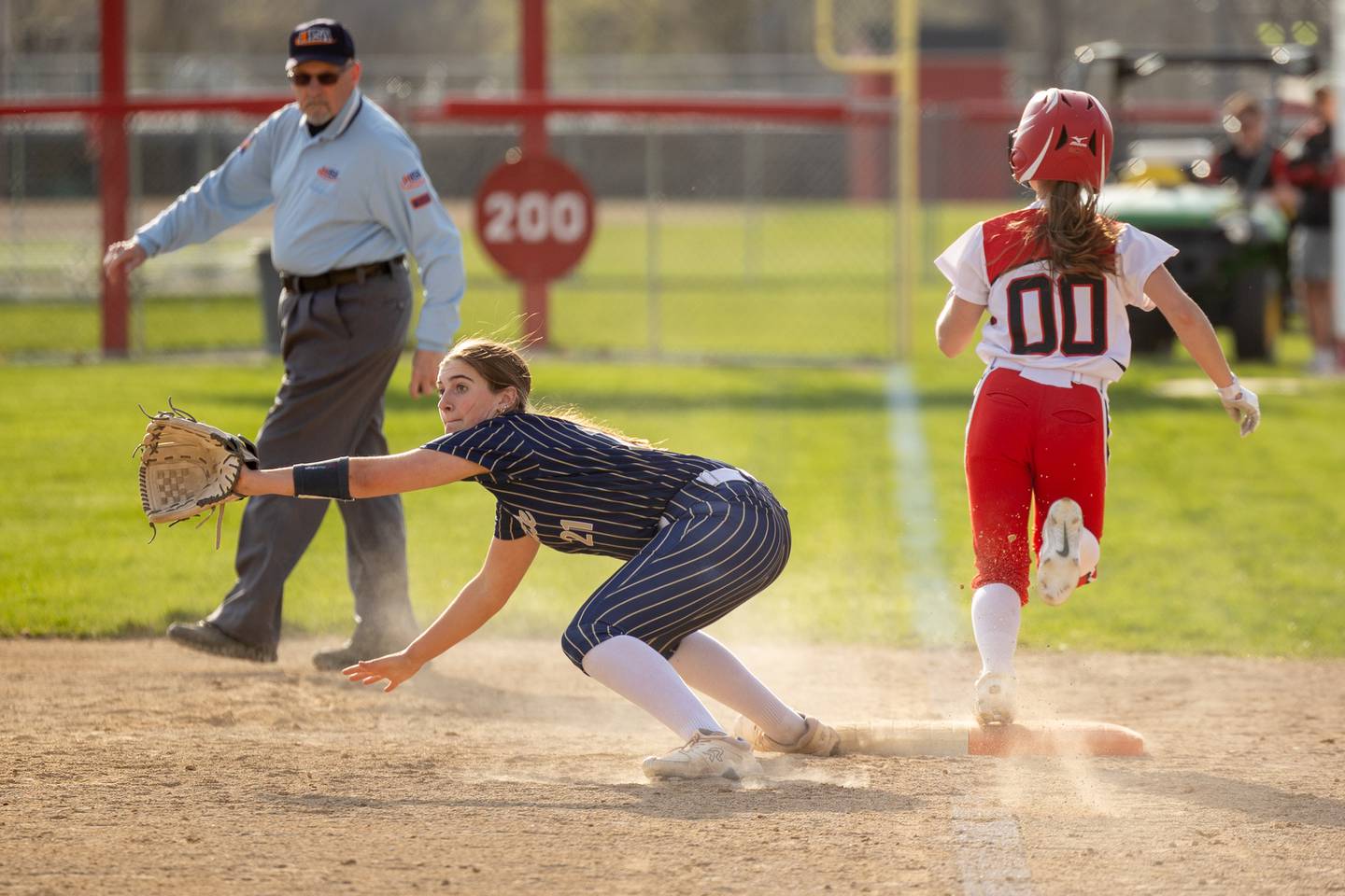 Kinley Rick (21) of Marquette reaches for ball whilst Kieran Black (00) of Streator safely gets on base on Wednesday, April 16, 2025 at Streator High School in Streator.