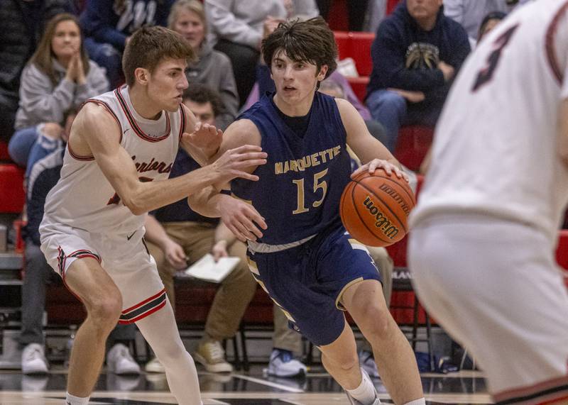 Alec Novotney of Marquette drives the ball to the hoop against Woodland's Quentin Porter during the varsity game on January 30, 2024.