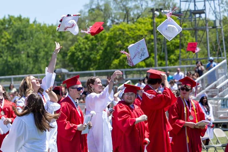 Graduates throw caps into air on Sunday, May 18, 2025 at Hall High School in Spring Valley.