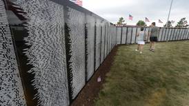 Veterans salute names on the Vietnam Traveling Memorial Wall in Peru 