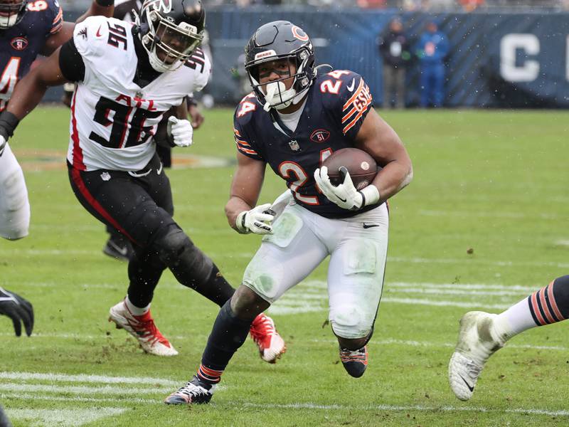 Chicago Bears running back Khalil Herbert gets by Atlanta Falcons defensive end Zach Harrison during their game Sunday, Dec. 31, 2023, at Soldier Field in Chicago.