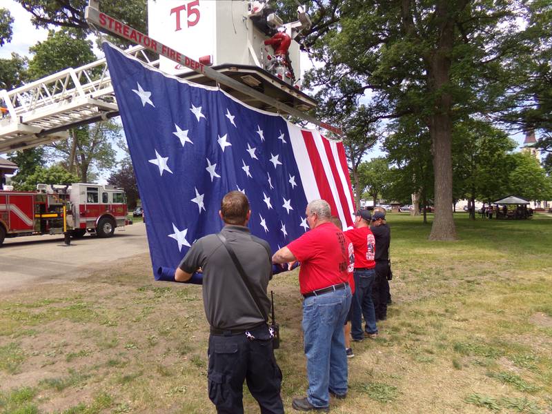 Streator firefighters roll up the flag Monday, May 29, 2023, after it flew above the Memorial Day ceremony at City Park.