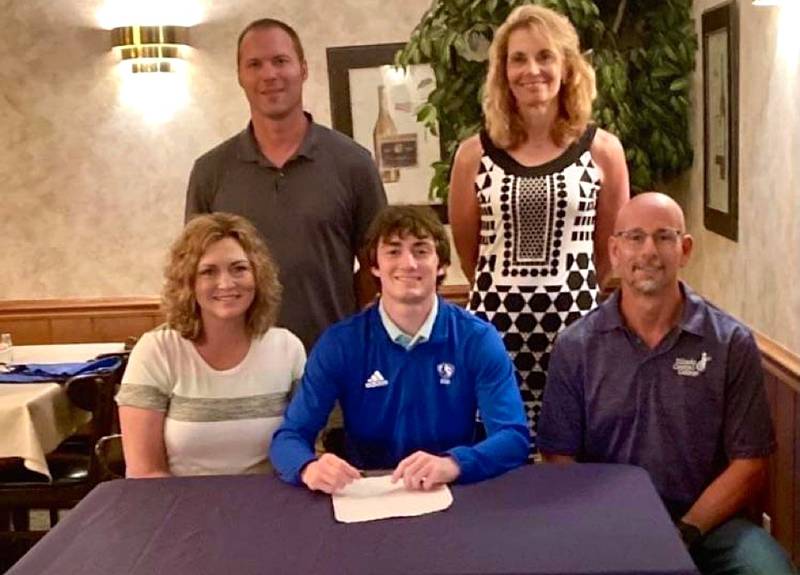 Fieldcrest's Mason Stoeger (seated, center) signs to run cross country and track and field at Eastern Illinois University. He was joined by his parents (seated) Kerri and Alex Stoeger and Fieldcrest coaches (standing) Keith Baldwin and Carol Bauer.