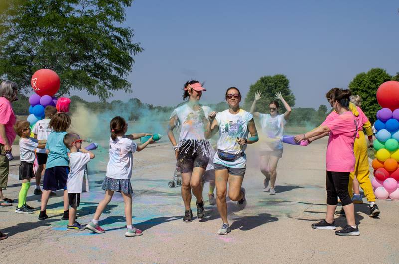 Volunteers coat runners in color as they cross the finish line in front of Sycamore Middle School during CASA DeKalb County's annual 5K Color Run on Saturday, June 3, 2023. Approximately $12,000 was raised for CASA from the color run, according to Jill Olson, executive director for CASA DeKalb County.