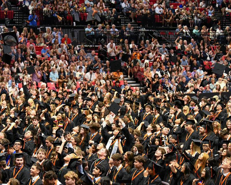 Caps fly into the air on Monday, May 18, 2026, signifying the end of graduation for the seniors of St. Charles East High School at the NIU Convocation Center in DeKalb.