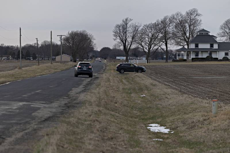 Curious onlookers check out the scene of a plane crash Friday, March 20, 2026, near the Whiteside County Airport.