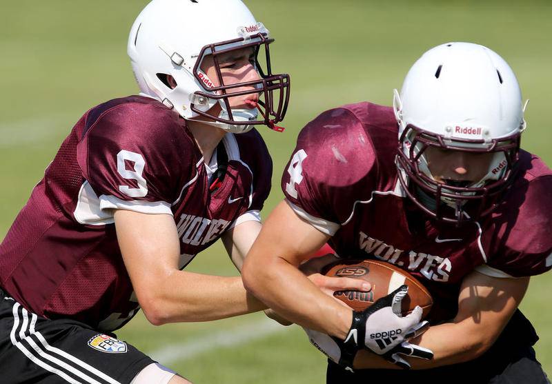 Prairie Ridge quarterback Connor Lydon hands the ball off to Jackson Willis during practice Friday. Lydon and Willis will each see expanded roles this season.