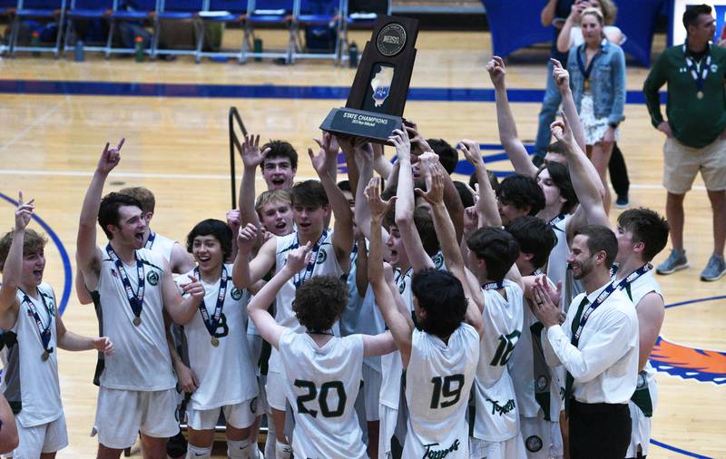 Glenbard West players raise the championship trophy after defeating Lyons Township in Saturday’s state boys volleyball championship match in Hoffman Estates.