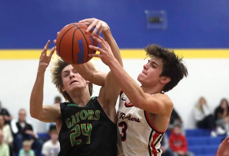 Crystal Lake South’s James Carlson, left, and Huntley’s Ty Goodrich battle during the title game of the Johnsburg Thanksgiving tournament in boys basketball on Friday.