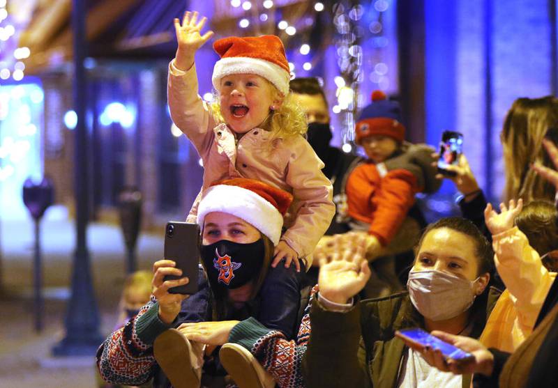 Kids wave at Santa as he parades down State Street during the Sycamore Chamber's Moonlight Magic event Friday Nov. 20 in downtown Sycamore.