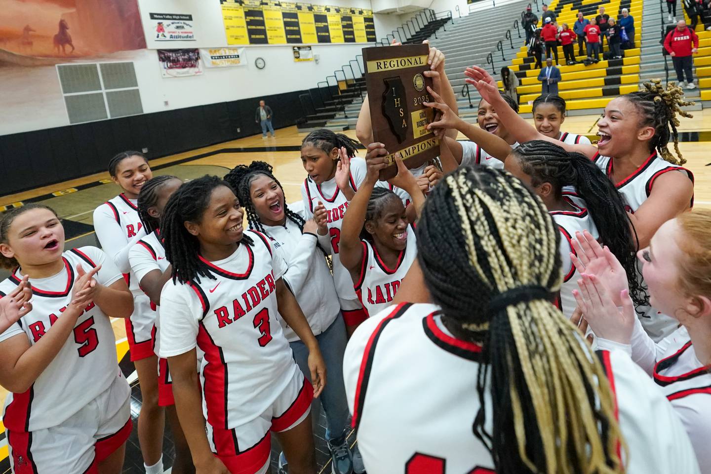 Bolingbrook's Airyel Jackson (1) holds up the Regional Championship plaque after defeating Yorkville to win a Class 4A Metea Valley Regional final basketball game at Metea Valley High School in Aurora on Friday, Feb. 21, 2025.