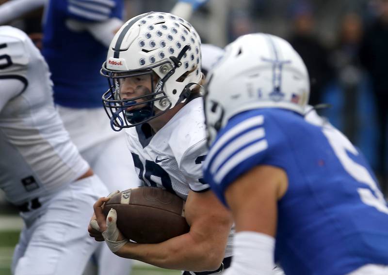 Cary-Grove's Holden Boone  runs with the ball as Geneva's Dylan Reyes chases him down during an IHSA Class 6A semifinal football game on Saturday, Nov. 23, 2024, at Geneva High School.
