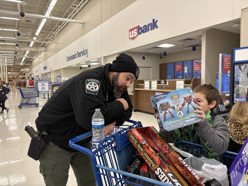 Andrew Riethmiller, left, looks at a transformer toy Silas Hayman, 8, of Wonder Lake picked out during Shop with a Cop Dec. 8, 2024 in McHenry.