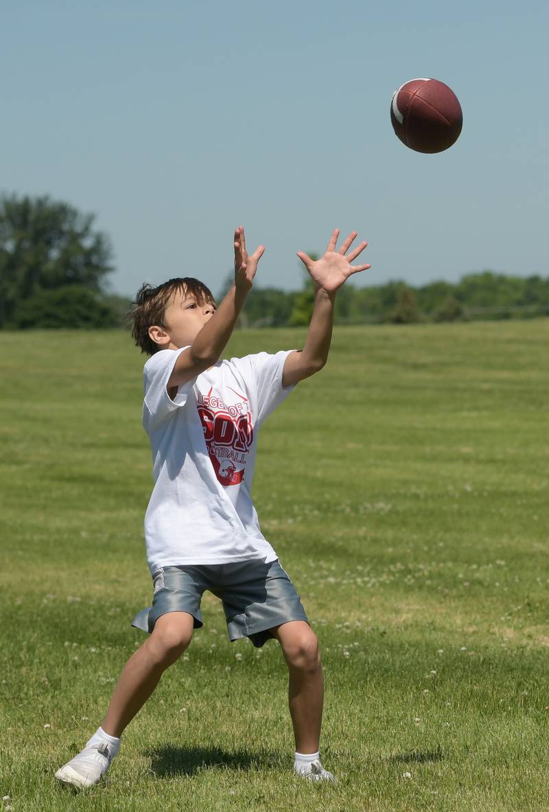 Harrison Loggins, 8 catches a pass from NIU quarterback Ethan Hampton during the inaugural Legends of the 60115 Football Camp in DeKalb on Sunday, June 26, 2022.