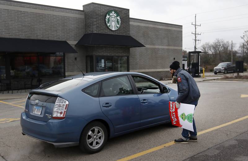 Mike Mueller, a Starbucks shift lead and a member of the union’s bargaining team, tries to convince a customer not to get a drink Thursday, Nov. 17, 2022, at the Cary location on Starbucks' Red Cup Day. Workers at Starbucks in Cary joined other workers across the country seeking to convince the company to better negotiate with its unionized locations.