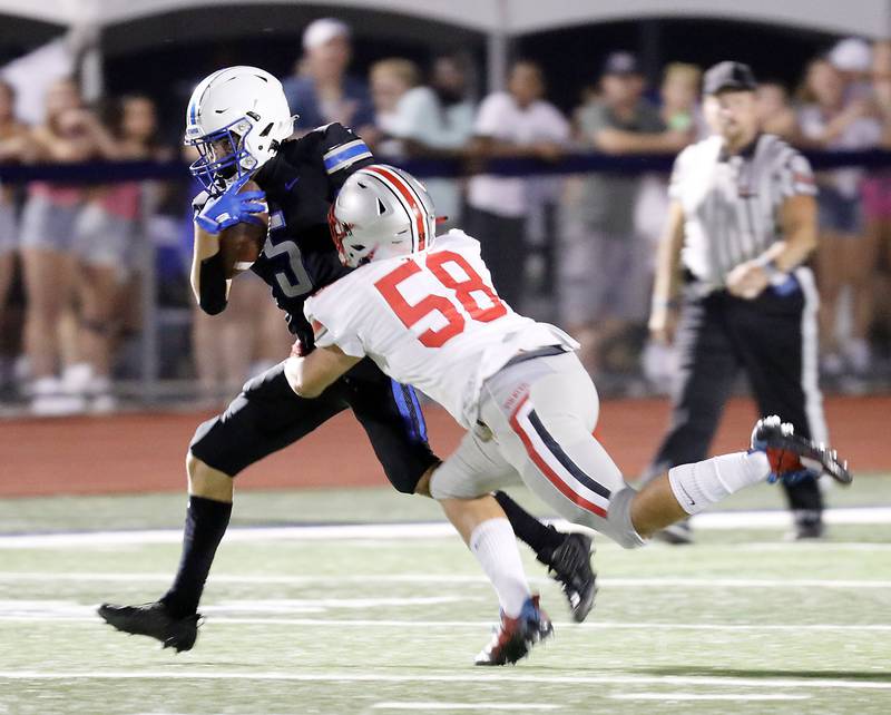 Palatine's Christian Courtney (58) brings down St. Charles North's Anthony Taormina (5) Friday August 25, 2023 in St. Charles.