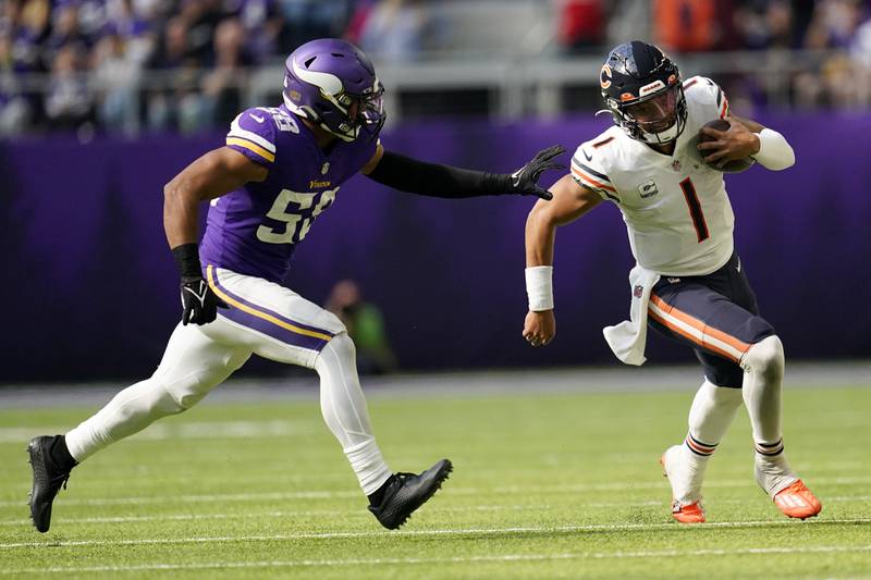 Chicago Bears quarterback Justin Fields runs from Minnesota Vikings linebacker Jordan Hicks during the second half, Sunday, Oct. 9, 2022, in Minneapolis.