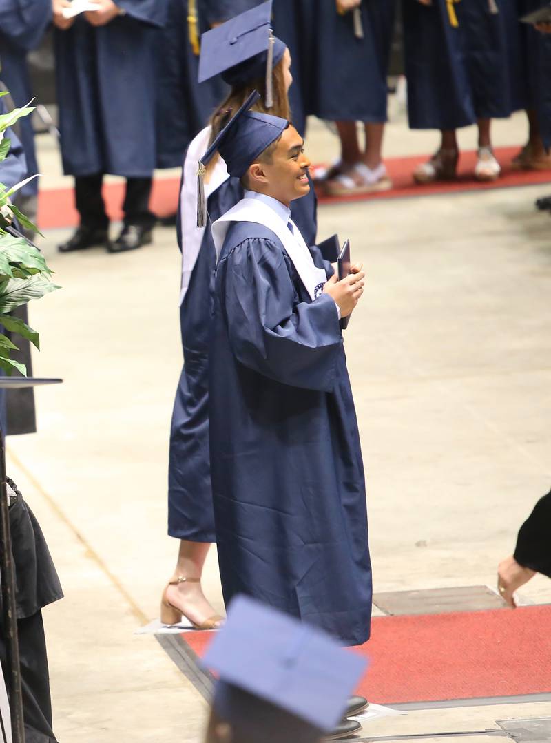 An Oswego East senior poses with his diploma moments after receiving it on May 21, 2022 in DeKalb.
