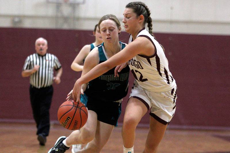 Marengo’s Gabby Gieseke pressures Woodstock North’s Allyson Schaid in varsity girls basketball at Marengo Tuesday evening.