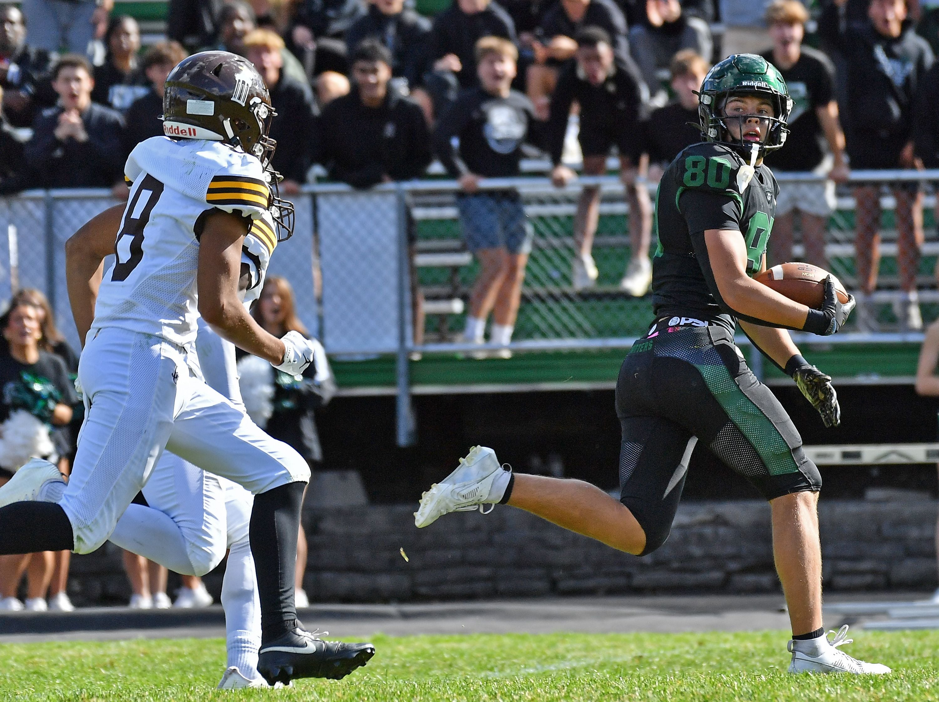 Glenbard West’s Brady Johnson (right) looks back at Joliet Catholic defenders as he makes a touchdown run after a catch during a game on September 6, 2025 at Glenbard West High School in Glen Ellyn.
