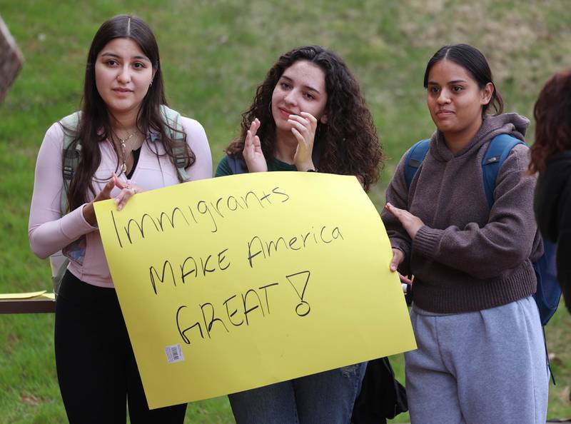 Three Northern Illinois University students applaud as they listen to U.S. Rep. Lauren Underwood, D-Naperville, speak Wednesday, April 23, 2025, during a rally to support NIU’s international students, faculty and staff. The event was held in front of Founders Memorial Library at NIU in DeKalb.