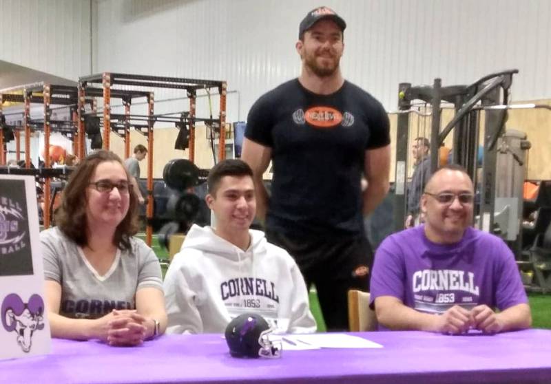 Estevan Alfaro (seated, center) will play football at Cornell College. He was joined by his parents (seated) Jose Alfaro and Imelda Alfaro and (standing) Mark Tabaka.
