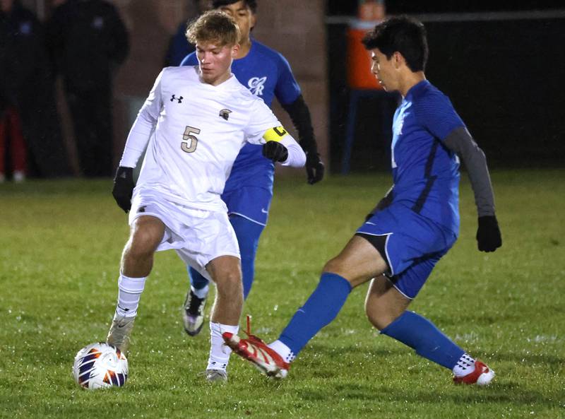 Sycamore's Aiden Sears kicks the ball away from Burlington Central’s Niko Guzman Tuesday, Oct. 21, 2025, during their IHSA Class 2A regional semifinal match at Burlington Central High School.