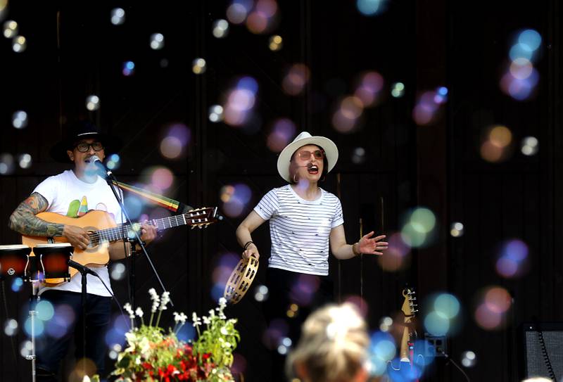 Mi Amigo Hamlet and Alina Celeste of Being Bilingual Rocks (BBR) Band perform during the Crystal Lake Park District and Public Library's Summer Singalong for Kids on Friday, June 21, 2024, at Crystal Lake's Main Beach. I love this photograph because of the way the bubbles seem to frame Mi Amigo Hamlet and Alina Celeste as they perform.