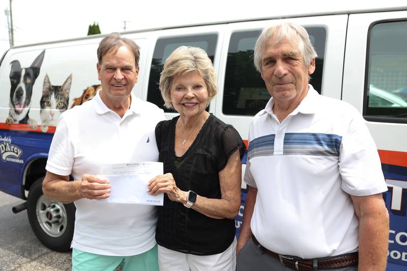 Jim Moody, left, presents a $7,000 check in memory of Susan Osmus, who was an avid animal lover, to Will County Humane Society Treasurer Jackie McTee along with Tom Osmus on Tuesday June 4, 2024 in Shorewood.