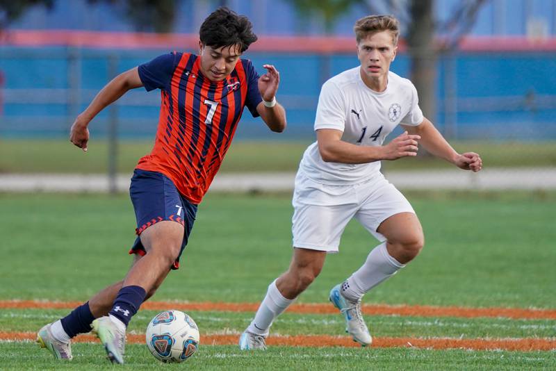 Oswego’s David Castro (7) plays the ball against Oswego East's Ryan Brandt (14) during a soccer match at Oswego High School on Tuesday, Oct. 1, 2024.