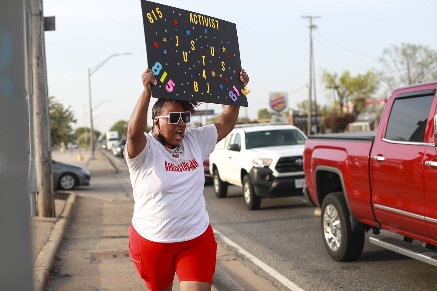 Latasha Simmons holds a sign and encourages motorists to honk to support justice for Eric Lurry, a Joliet man who died of an overdose in police custody, on Tuesday, April 27, 2021, at the corner of Larkin Ave. and Jefferson st. in Joliet, Ill.