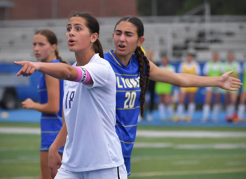 Downers Grove North’s Campbell Thulin and Lyons Township’s Lena Giustini (20) offer differing points of view to an official during their Class 3A Lyons Regional final on May 23, 2026 at Lyons Township High School in LaGrange.