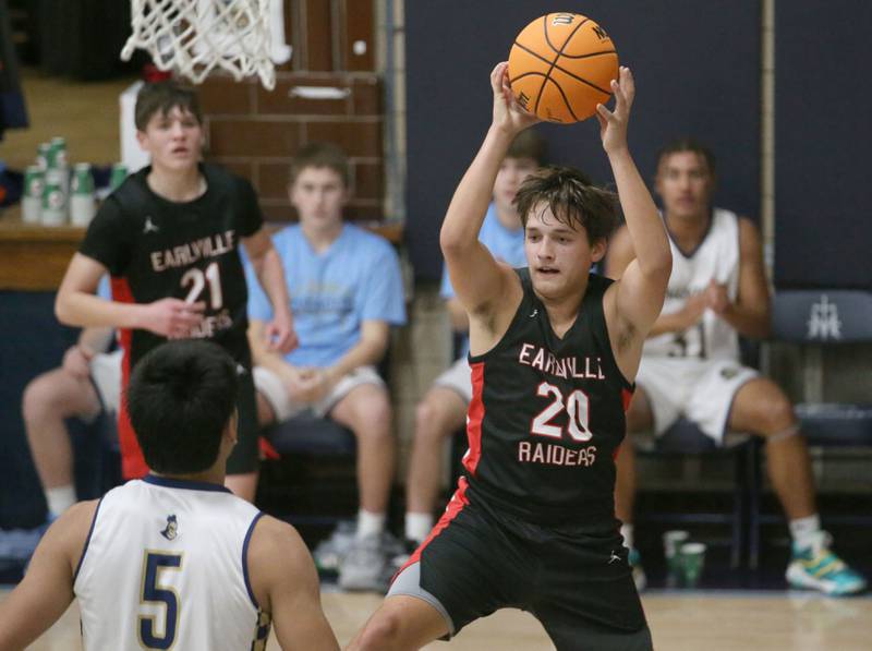 Earlville's Grady Harp looks to pass the ball over Marquette's Blayden Cassel on Friday, Jan. 3, 2025 in Bader Gym at Marquette High School.