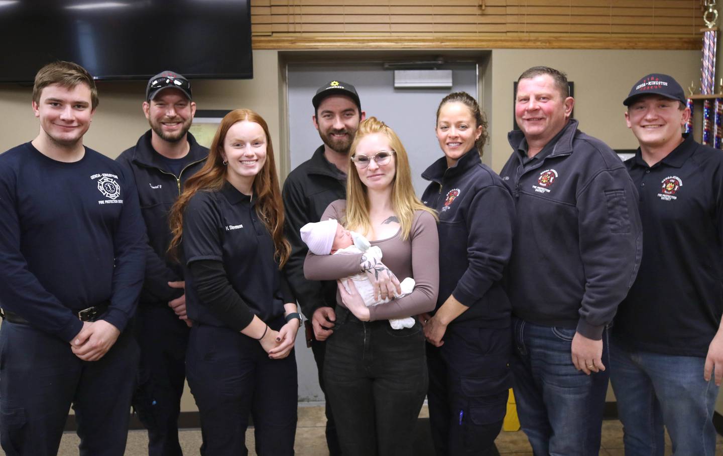 Members of the Genoa-Kingston Fire Department who had a hand in the delivery along side baby Eleanor Lee Altepeter-Knotts, and her parents Sammie Altepeter and Brodie Knotts (middle) from Kingston Thursday, Nov. 2, 2023, at the Genoa-Kingston Fire Department in Genoa. A crew from the department delivered the baby in the ambulance along the side of the road Sept. 29 when they realized they weren’t going to make it to the hospital in time.