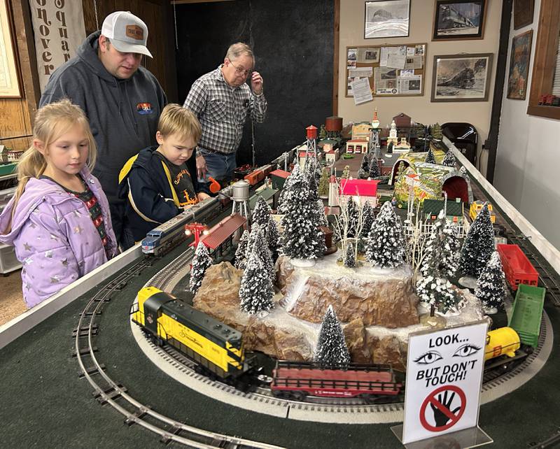 Tim Grote and his children, Brielynn, 7, and and Jase, 3, watch a model train at the Blackhawk Model Train Club in Conover Square Mall during Oregon's Candlelight Walk on Saturday, Dec. 6, 2025.
