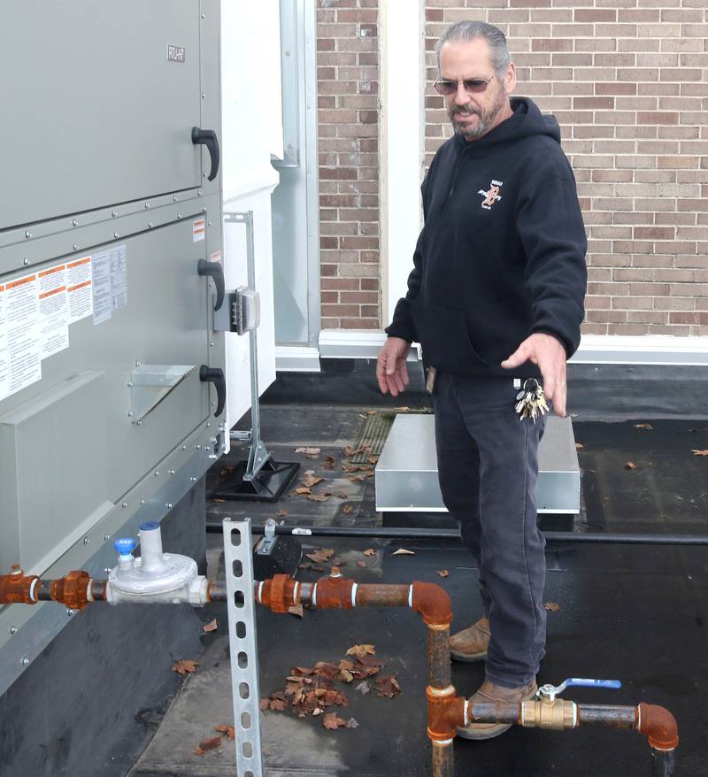 James Orr, with DeKalb School District 428 maintenance, talks Thursday, Nov. 3, 2022, about the piping for the new air conditioning units on the roof of Huntley Middle School.