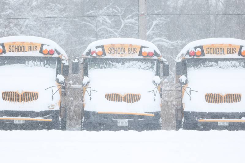 Snow covered buses sit in the lot of Firstgroup America as schools closed due to the winter storm. Wednesday, Feb. 2, 2022, in Joliet.