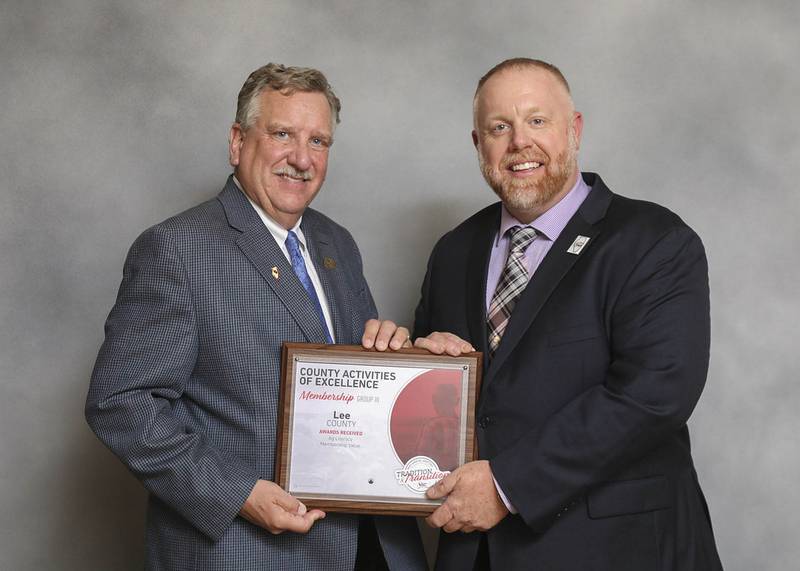 Brian Duncan, Illinois Farm Bureau vice president, at left, presents an award to Adam Henkel, Lee County Farm Bureau president.